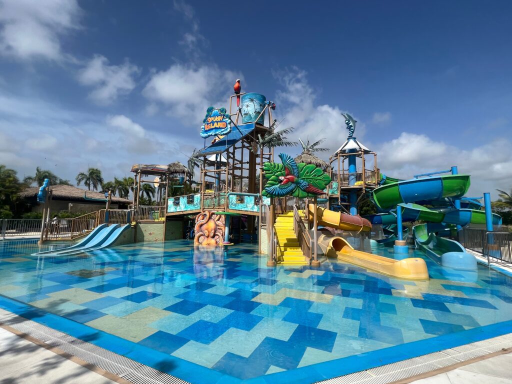 Children's waterpark with multiple slides, water fountains, and a splash area.